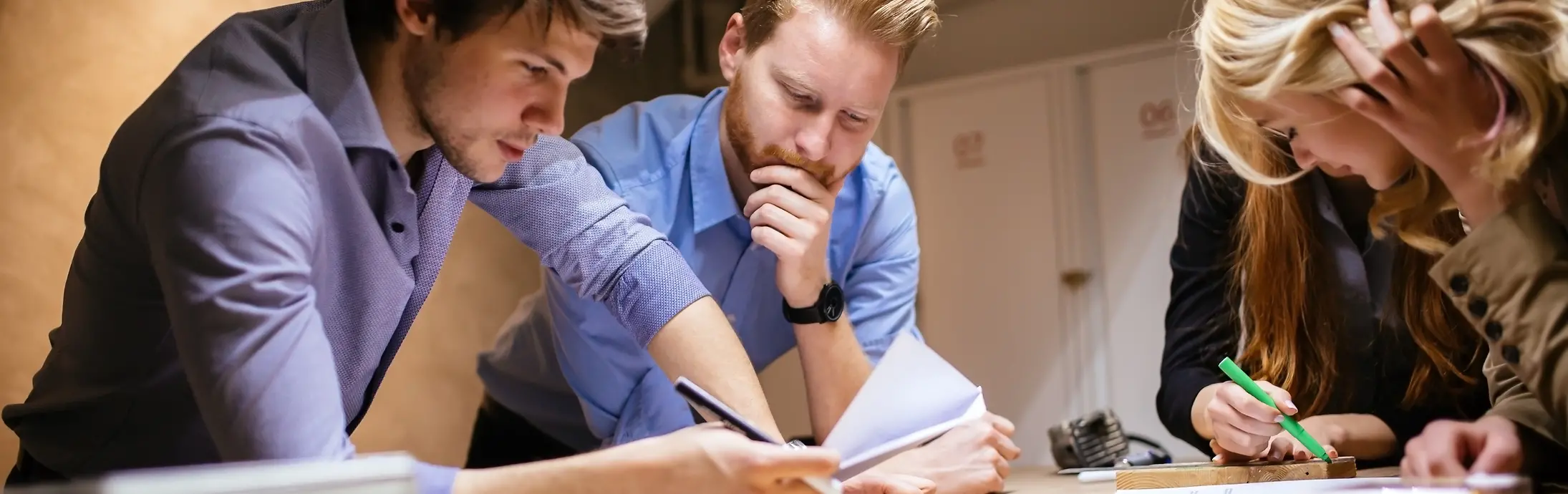 4 kolléga egy asztalra támaszkodva ellenőrzi a papírokat